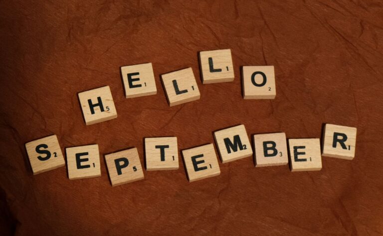 hello september written in scrabble letters on brown paper